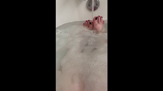 Curvy babe soaks in a bubble bath showing off her black-painted toes